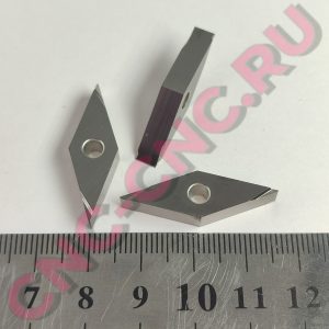 Close-up of two metallic L-shaped brackets with circular holes, placed over a ruler background.